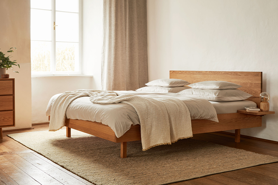 Helles Schlafzimmer mit Holzbett und natürlicher ruhiger Atmosphäre