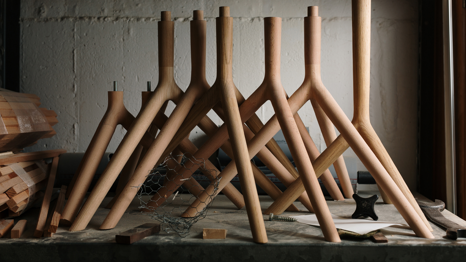 Reihe von V-förmigen Holzkomponenten die ordentlich aufgereiht in einer Werkstatt stehen