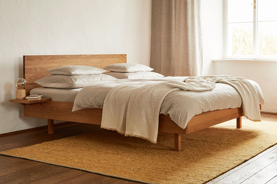 Helles Schlafzimmer mit Holzbett und beigem Teppich in ruhiger Atmosphäre