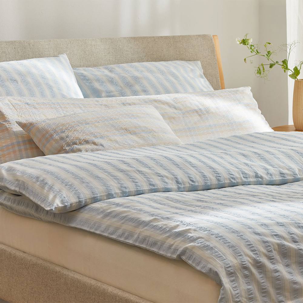 Gestreifte Bettwäsche im grauen Bett