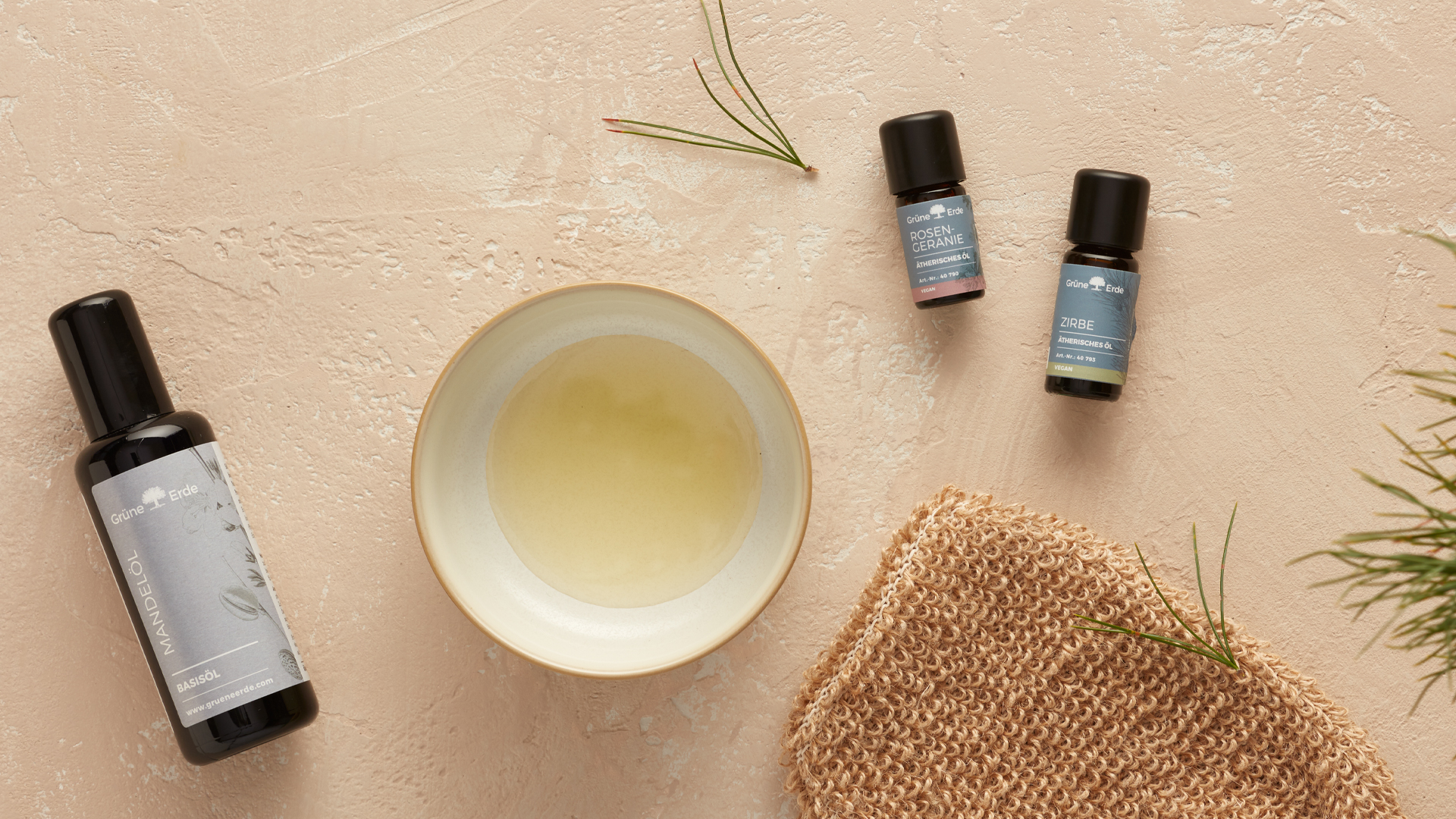Basisöl und ätherische Öle neben einer Schale mit Öl