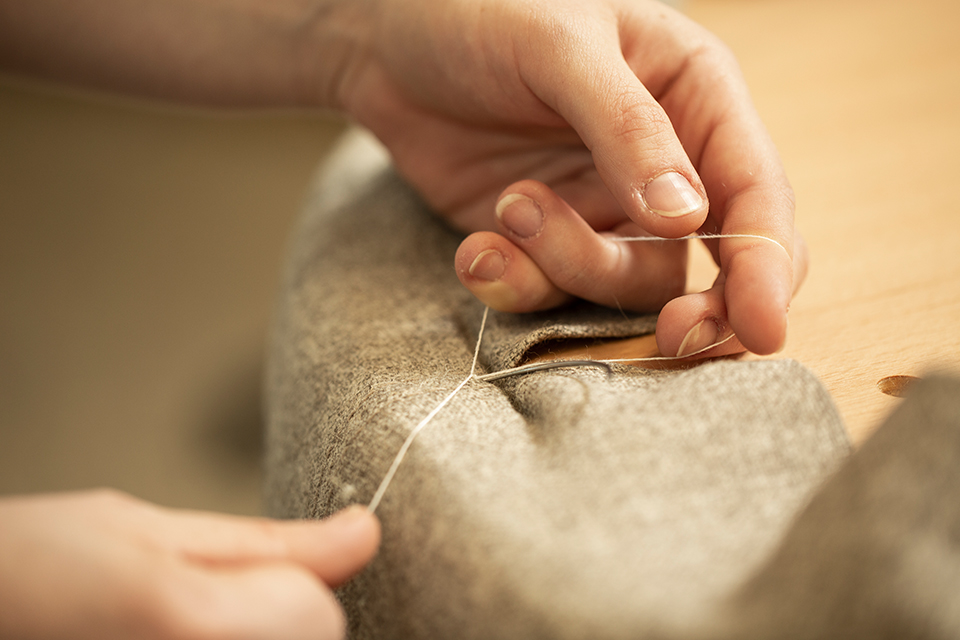 Mitarbeiterin die gerade die Polsterung auf einen Stuhl gibt
