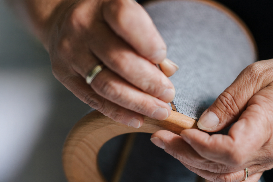 Person arbeitet sorgfältig an einer Lampe