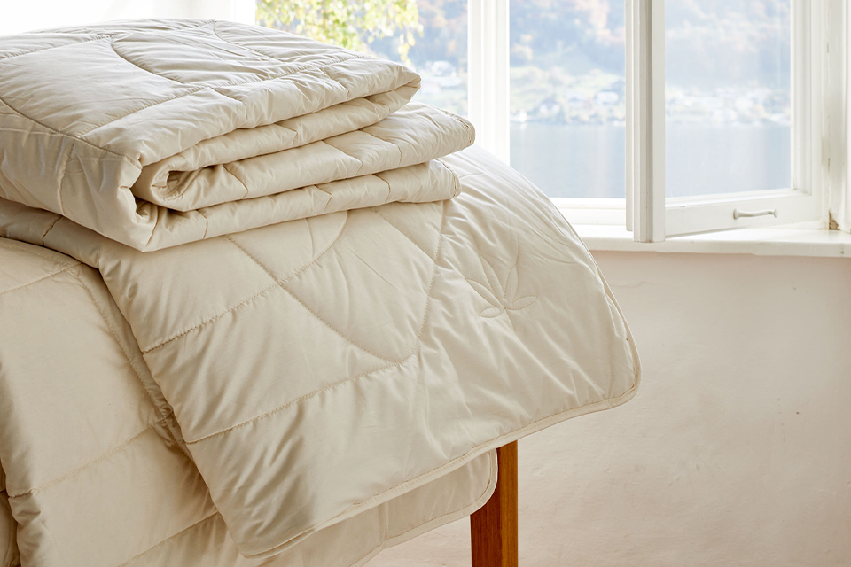 Sommerdecken auf einer Holzbank vor einem offenen Fenster