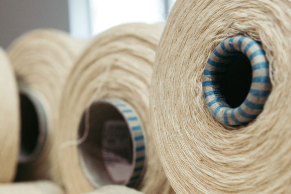 Drei nebeneinanderliegende Stoffbanderolen  auf einem Stapel