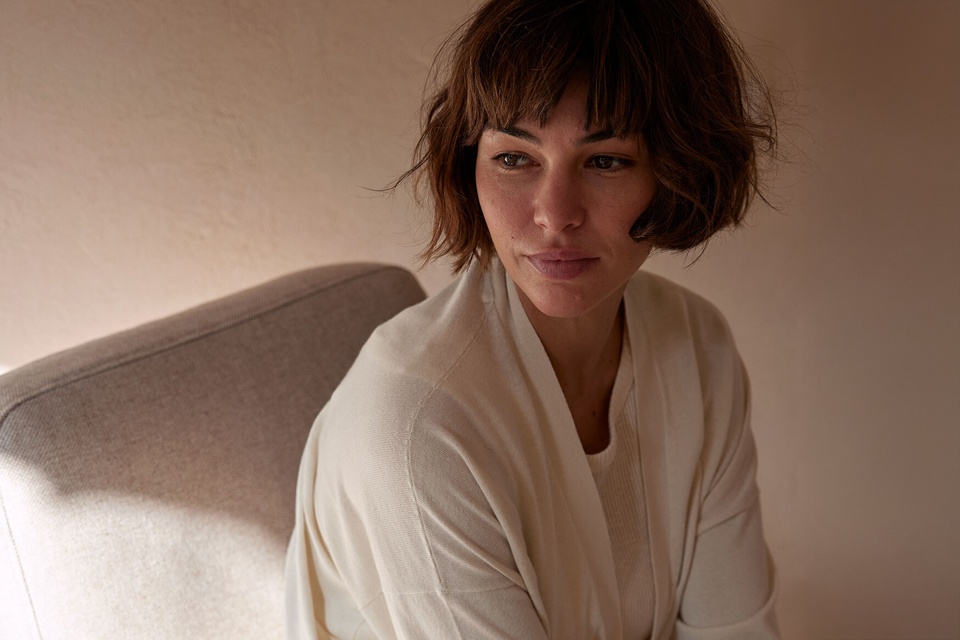 Portrait einer Frau die auf einem Polstermöbel entspannt