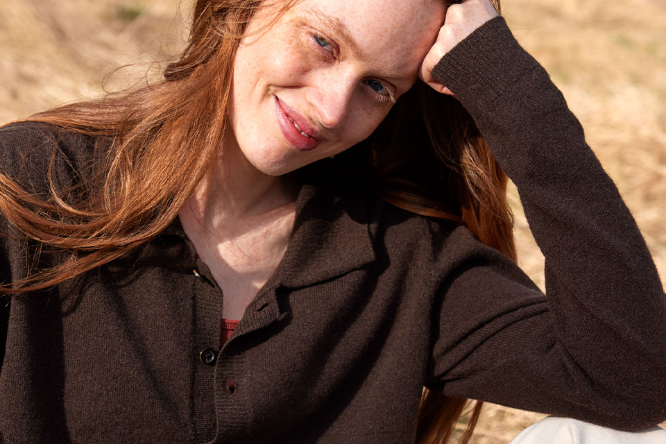 Nahaufnahme einer Frau mit braunem Sweatshirt im Sonnenlicht